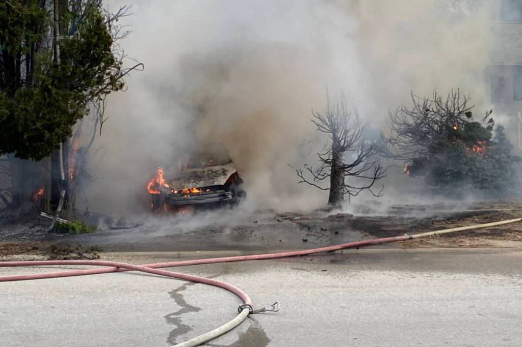 A car fully engulfed by fire in the driveway of a Timmins Street property in Penticton on March 14, 2026. (Logan Lockhart/Western News)